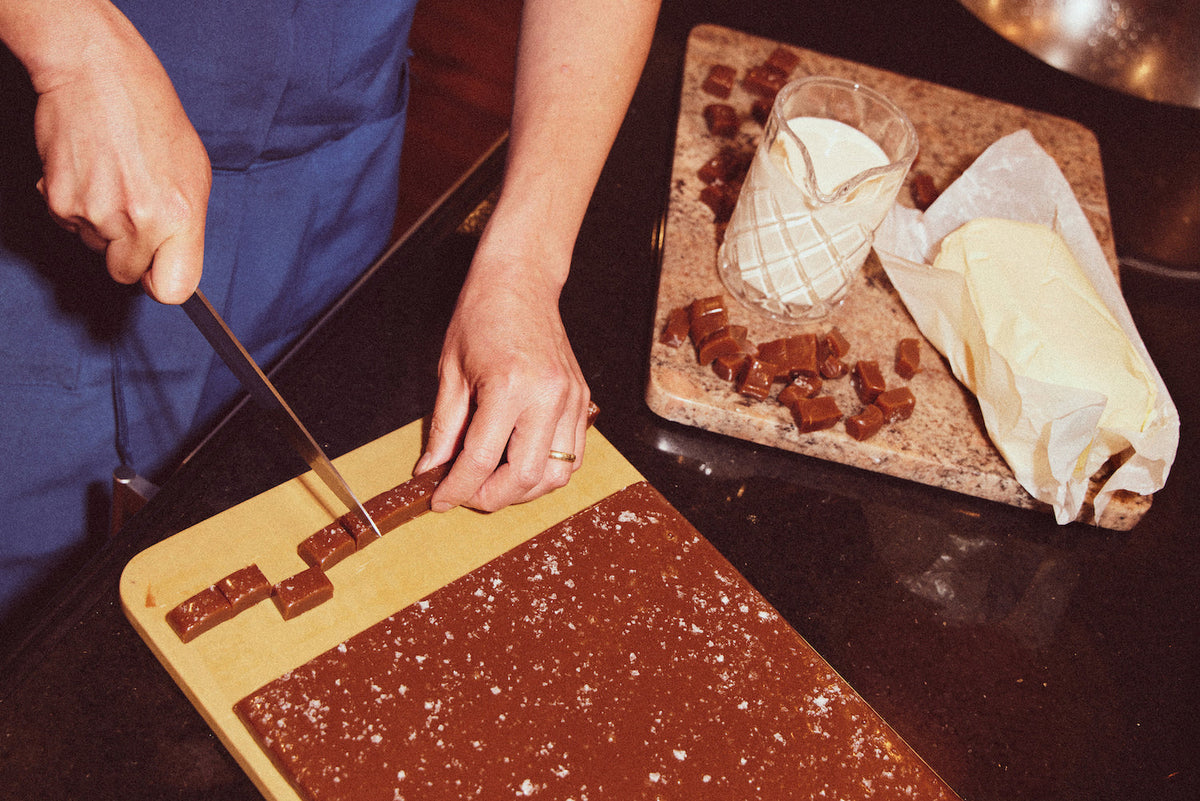 Photo of someone cutting caramel blocks with a knife