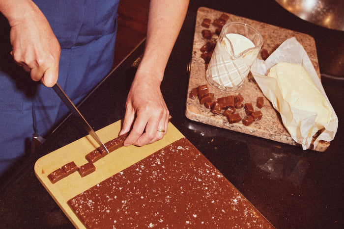 Photo of someone cutting caramel blocks with a knife